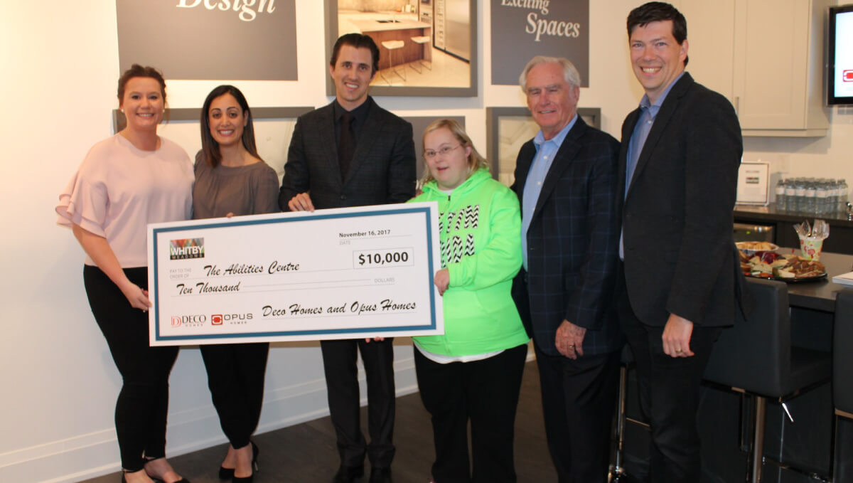 Deco Homes team holding up giant cheque